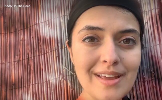 a close up of a woman's face against a bamboo screen