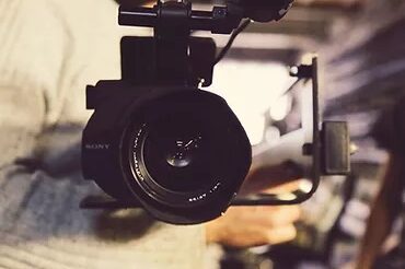 a camera being held by a person in a white shirt