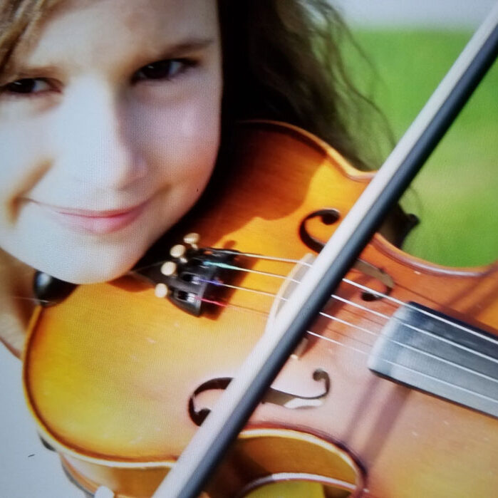Little girl play the violin up close